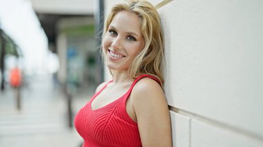 Sokakta kendine güvenen genç sarışın kadın gülümsüyor