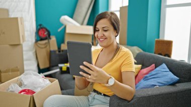 Orta Doğulu bir kadın yeni evinde tablet kullandığından emin bir şekilde gülümsüyor.