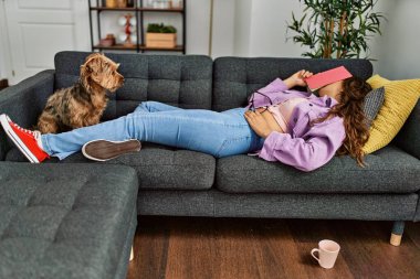 Genç, güzel İspanyol kadın yüzünü kitapla örterek evde uyuyor.