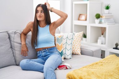 Genç esmer kadın evdeki kanepede oturuyor. Kafası karışık ve soru soruyor. Şüpheyle kararsız, kafa kafaya düşünerek. Düşünceli kavram. 