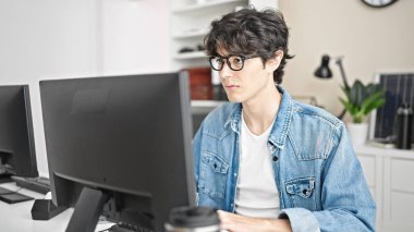 Young hispanic man business worker using computer working at office
