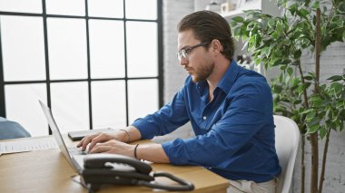 Ofiste çalışan İspanyol bir iş adamı dizüstü bilgisayar kullanıyor.