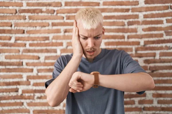 Young Caucasian Man Standing Bricks Wall Looking Watch Time Worried — Stock Photo, Image