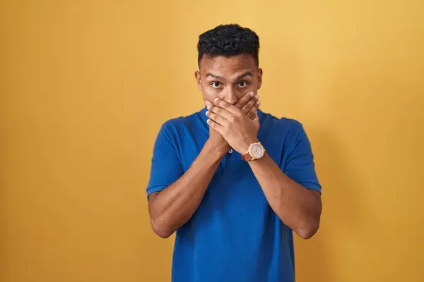 Ung Latinamerikansk Man Står Över Gul Bakgrund Chockad Täcker Munnen — Stockfoto