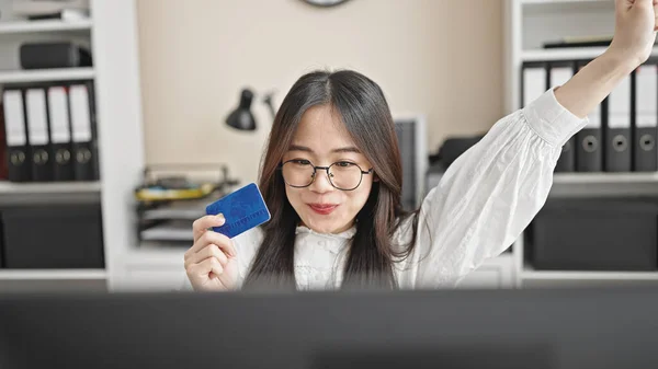 Young chinese woman business worker shopping with computer and credit card at office
