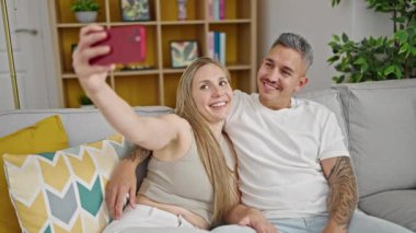 Akıllı telefonlu genç mutlu çift selfie çekiyor.