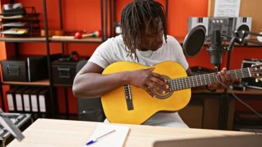 Afrikalı Amerikalı müzisyen müzik stüdyosunda klasik gitar besteliyor.