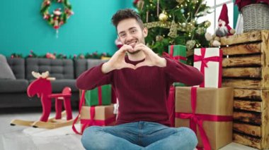 Genç ve yakışıklı bir adam Noel zamanı elleri kalp şeklinde