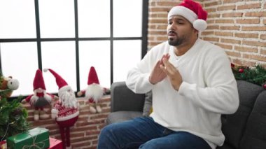 Evdeki kanepede oturan adam.