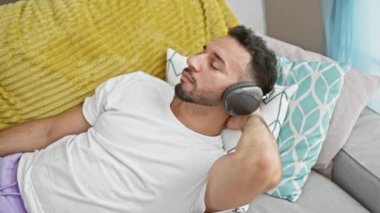 Pijamalı bir gencin portresi. Evde kulaklıkla müzik dinliyor. Kapatın.