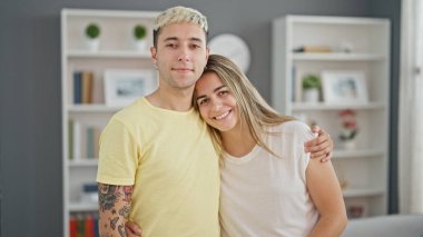 Güzel bir çift gülümsüyor. Evde birbirlerine sarılıyorlar.