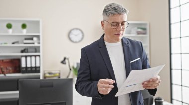 Genç Kafkasyalı iş adamı ofiste belge okuyor.