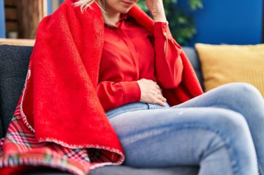 Genç sarışın kadın evde baş ve mide ağrısı çekiyor.