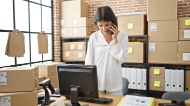 Genç, güzel İspanyol bir kadın. İş adamı. Ofisteki bilgisayarla akıllı telefondan konuşuyor.