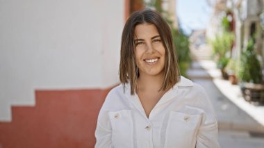 Genç, güzel İspanyol kadın tipik İspanyol kasabasına gülümsüyor.