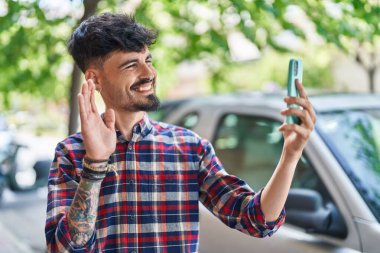 Latin asıllı genç adam gülümsüyor.