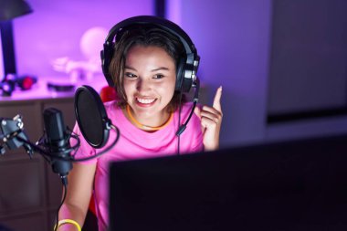 Bir fikirle ya da soru sorarak gülümseyen İspanyol genç kadın mutlu bir yüzle işaret ediyor. 