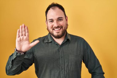 Ayrıca sarı arka planda sakallı İspanyol bir adam var. Mutlu ve güler yüzlü bir şekilde merhaba diyor. 