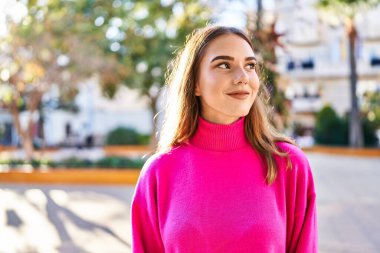 Young woman smiling confident looking to the side at park