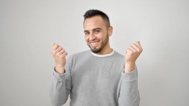 Hispanik adam kendinden emin gülümsüyor. Soyutlanmış beyaz arka plan üzerinden para harcıyor.