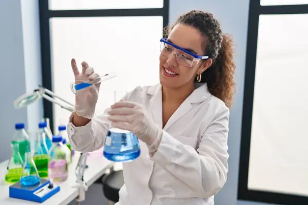 年轻美丽的惊慌失措的女科学家在实验室把液体倒在试管上 — 图库照片