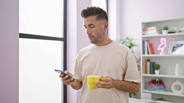 Homem Hispânico Jovem Atraente Enviando Mensagens Texto Diligentemente Smartphone Enquanto — Fotografia de Stock