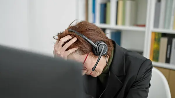 Mature hispanic woman university teacher wearing headset feeling anxious at library university