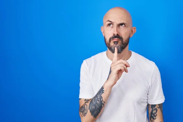 Hispanic Man Tattoos Standing Blue Background Thinking Concentrated Doubt Finger — Stock Photo, Image