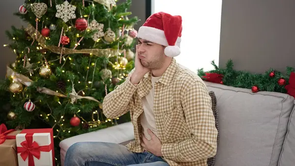 Jovem Hispânico Sofrendo Dor Estômago Sentado Árvore Natal Casa — Fotografia de Stock