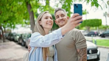 Sokakta selfie çeken genç çift.