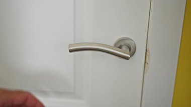 Kapı kolu olan bir erkek eli.