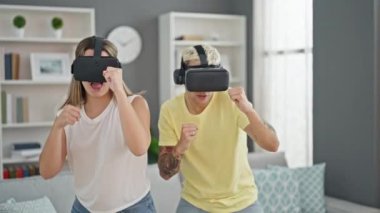 Evde sanal gerçeklik gözlüğü kullanarak boks oynayan güzel bir çift.