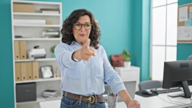 Genç iş kadını bilgisayarda çalışırken parmağıyla işaret ediyor.