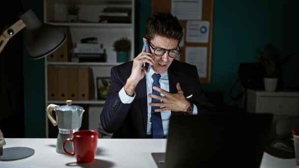 Молодий Іспаномовний Чоловік Бізнесмен Розмовляє Смартфонах Сперечаючись Офісі — стокове відео
