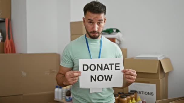 Joven Árabe Voluntario Sosteniendo Donar Ahora Mensaje Sonriendo Centro Caridad — Vídeo de stock