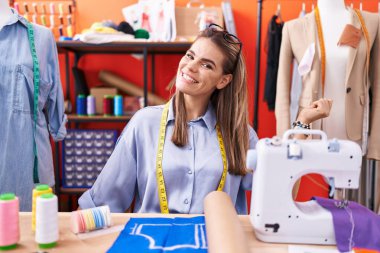 Atölye odasında dans eden İspanyol kadın terzi mutlu ve neşeli, hareketli ve kendinden emin bir şekilde müzik dinliyor. 