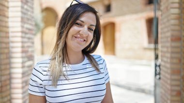 Orta Doğulu bir kadın sokakta kendinden emin gülümsüyor