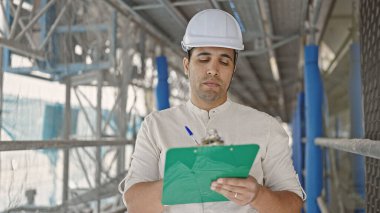 Genç İspanyol mimar sokakta rahat bir ifadeyle belgeye yazı yazıyor.