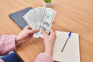 Young beautiful plus size woman counting dollars at office