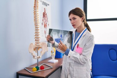 Rehabilitasyon kliniğinde ciddi yüzü olan genç sarışın fizyoterapist.