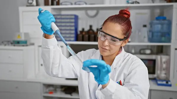 Steely-eyed young redhead woman scientist, laser-focused, pouring crucial liquid measure into a test tube, engrossed in serious research work within her bustling laboratory.