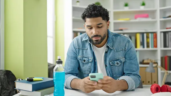 stock image African american man student using smartphone at library university