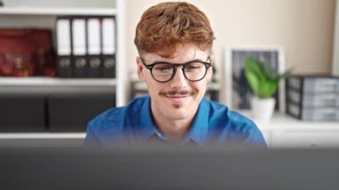 Ofiste bilgisayarla çalışan mutlu iş adamı