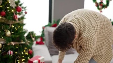 Evde Noel hediyesi tutan yakışıklı genç adam. 