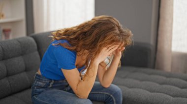 Evdeki kanepede oturan genç kadın strese girdi.