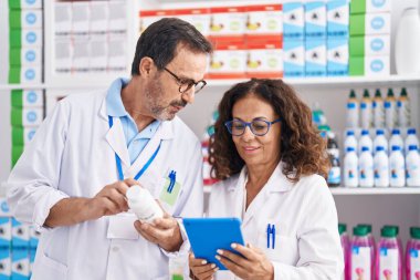 Eczanede dokunmatik ped kullanan erkek ve kadın eczacılar.