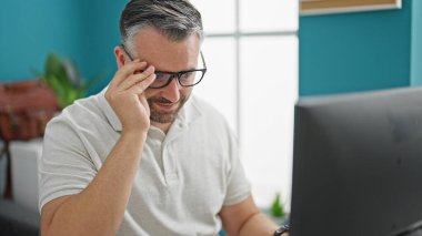 Ofisteki bilgisayarı kullanan gri saçlı iş adamı.