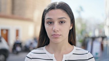 Sokakta ciddi bir ifadeyle duran genç, güzel İspanyol kadın.