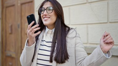 Sokak ortasında müzik dinleyen ve dans eden genç, güzel İspanyol kadın.