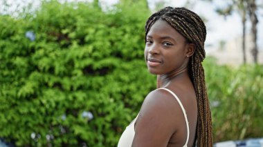 African american woman standing with serious expression at park